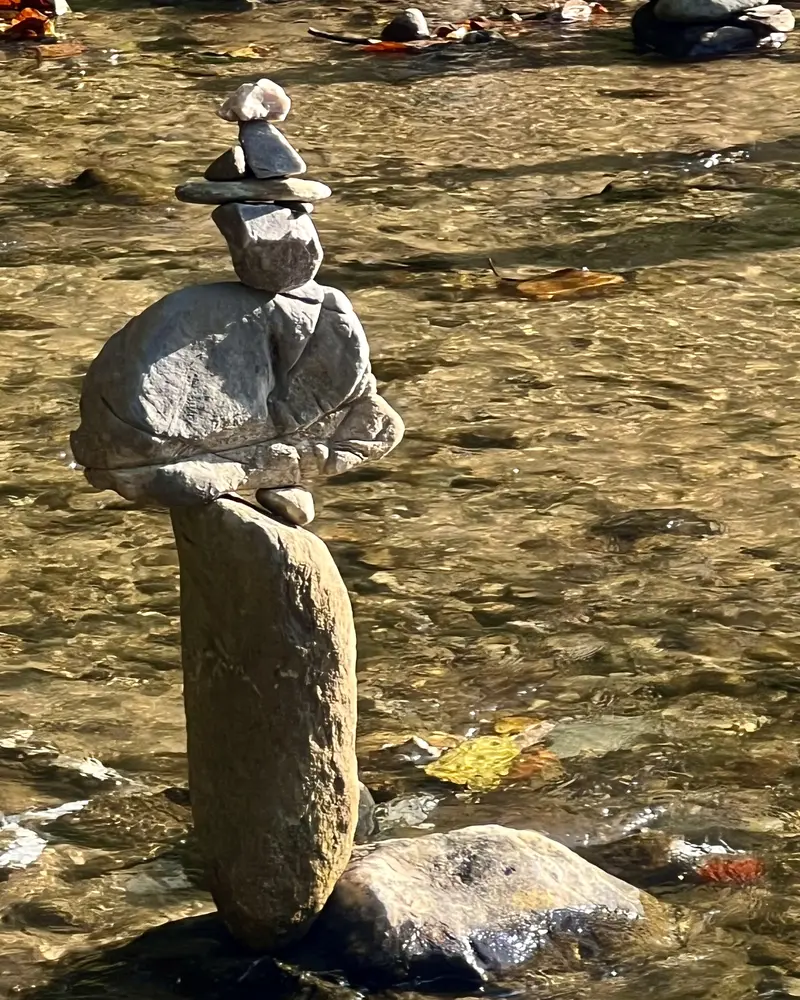 Smooth stones balanced in a cairn in a shallow stream